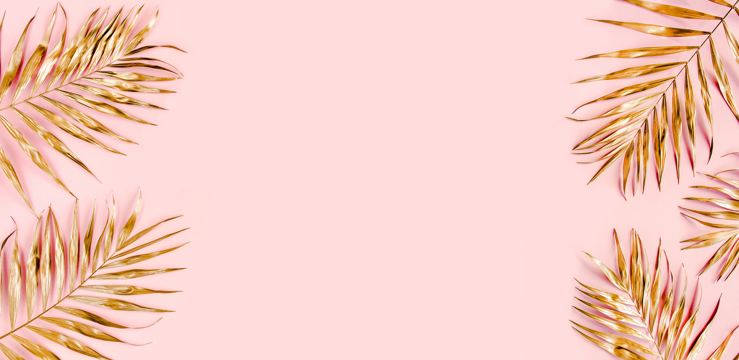 Gold tropical palm leaves on pink background. Flat lay, top view minimal concept.